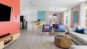 Un salon moderne avec un téléviseur, un canapé et une table basse.