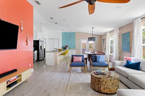 Ein modernes Wohnzimmer mit Fernseher, Sofa und Couchtisch.