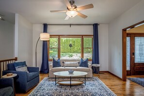 Ein Wohnzimmer mit einer Couch, einem Couchtisch und einem Deckenventilator.