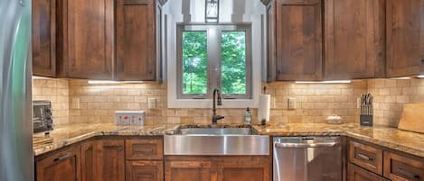 A kitchen with wooden cabinets, a stainless steel sink, and a dishwasher.