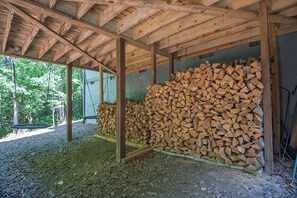 Eine hölzerne Schutzhütte mit Holzstapel und Schaukel.