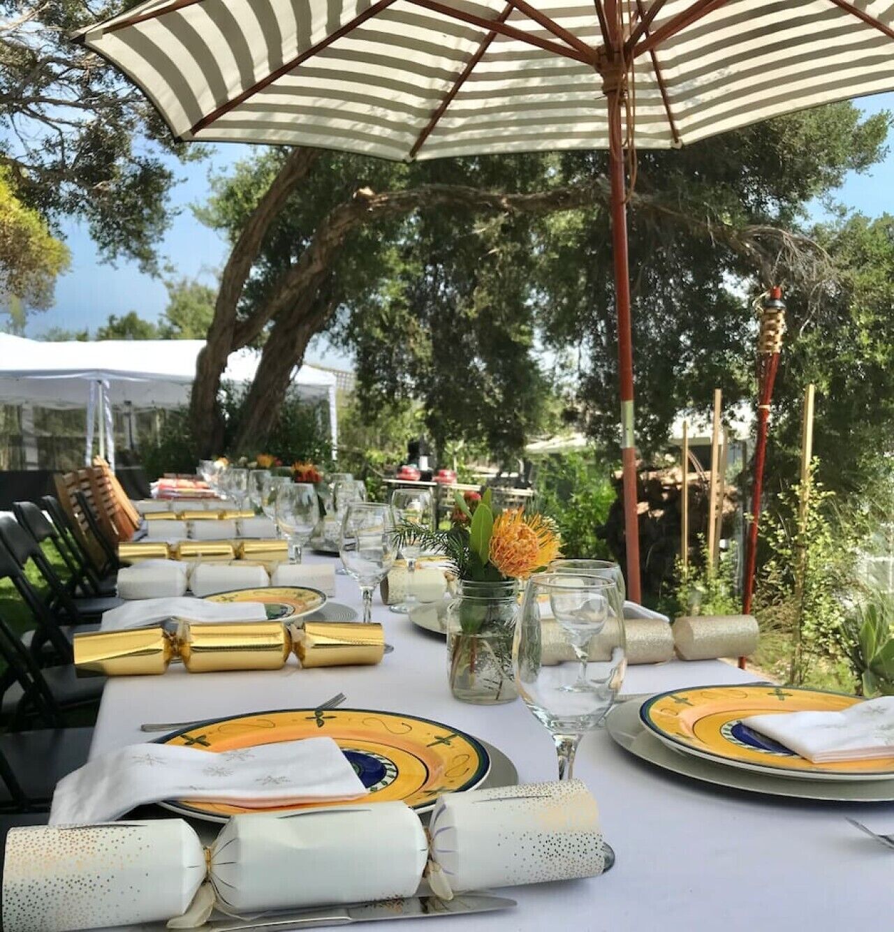 An outdoor dining setup with striped umbrellas, neatly arranged tables, and chairs.