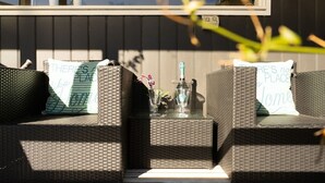 A wicker outdoor seating area with two chairs and a small table, each with a pillow that reads 'THERE'S NO PLACE LIKE HOME.' - Chiara`s Art Cottage 3BR Coastal Garden Retreat (Sorrento)