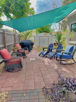 A patio with outdoor furniture, a barbecue grill, and a covered area. - Charming Mid Century Modern Home w/office and large outdoor space (St. Petersburg)