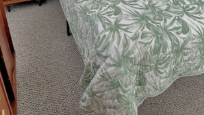 Ein Schlafzimmer mit einem Bett, zwei Nachttischen und zwei Lampen.