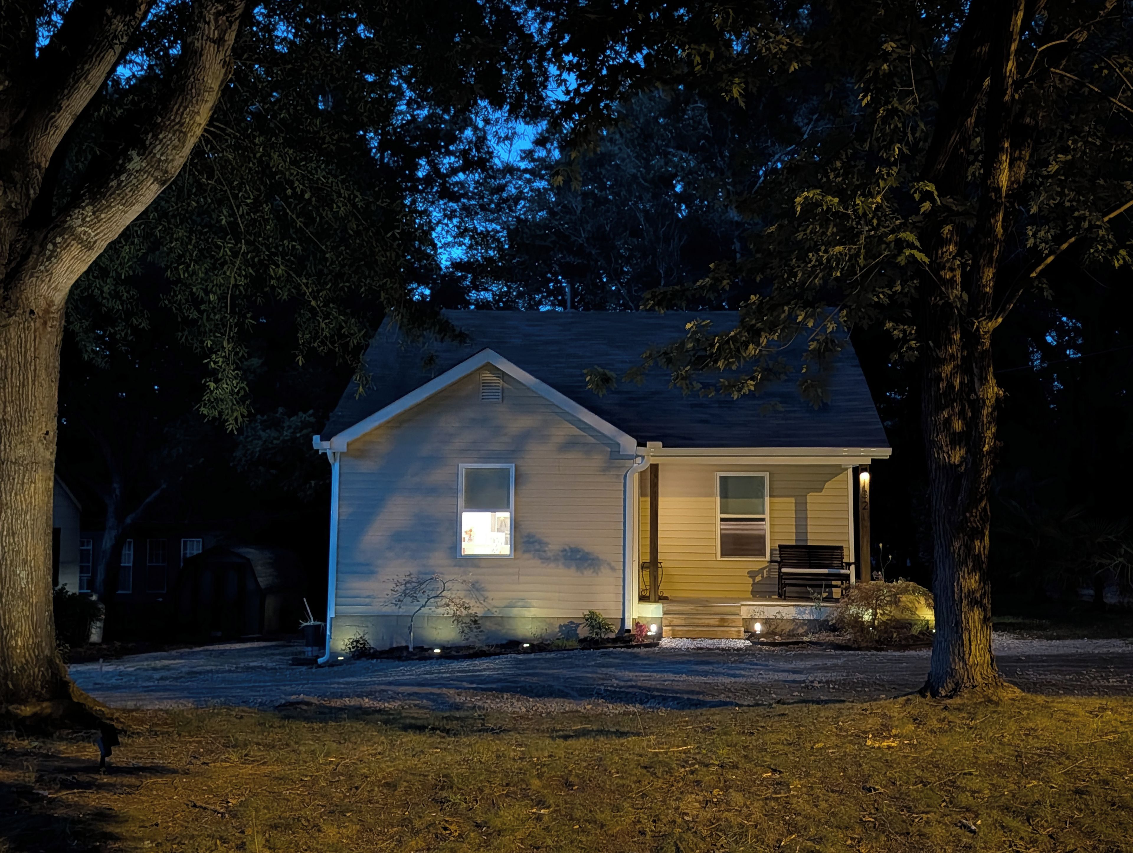 A single-story house with a front porch, a small window, and a door.
