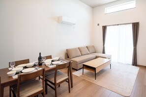A modern living room with a dining area, a sofa, and a coffee table. - North Point Kamifurano (Sorachi-gun,Kamifurano-cho)