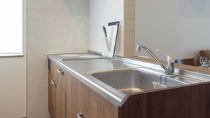 A modern kitchen with a stainless steel sink, wooden cabinets, and a knife holder. - North Point Kamifurano (Sorachi-gun,Kamifurano-cho)