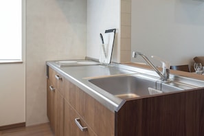 A modern kitchen with a stainless steel sink, wooden cabinets, and a knife holder. - North Point Kamifurano (Sorachi-gun,Kamifurano-cho)