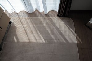 A room with a bed, wooden flooring, and a window with sheer curtains. - North Point Kamifurano (Sorachi-gun,Kamifurano-cho)