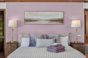 A bedroom with a bed, pillows, a painting, and two bedside lamps. - Spacious 4-bedroom house minutes from Lake Arrowhead for a relaxing stay (Lake Arrowhead)