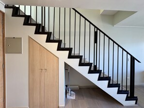 Eine Treppe mit schwarzen Geländern und Holzstufen.