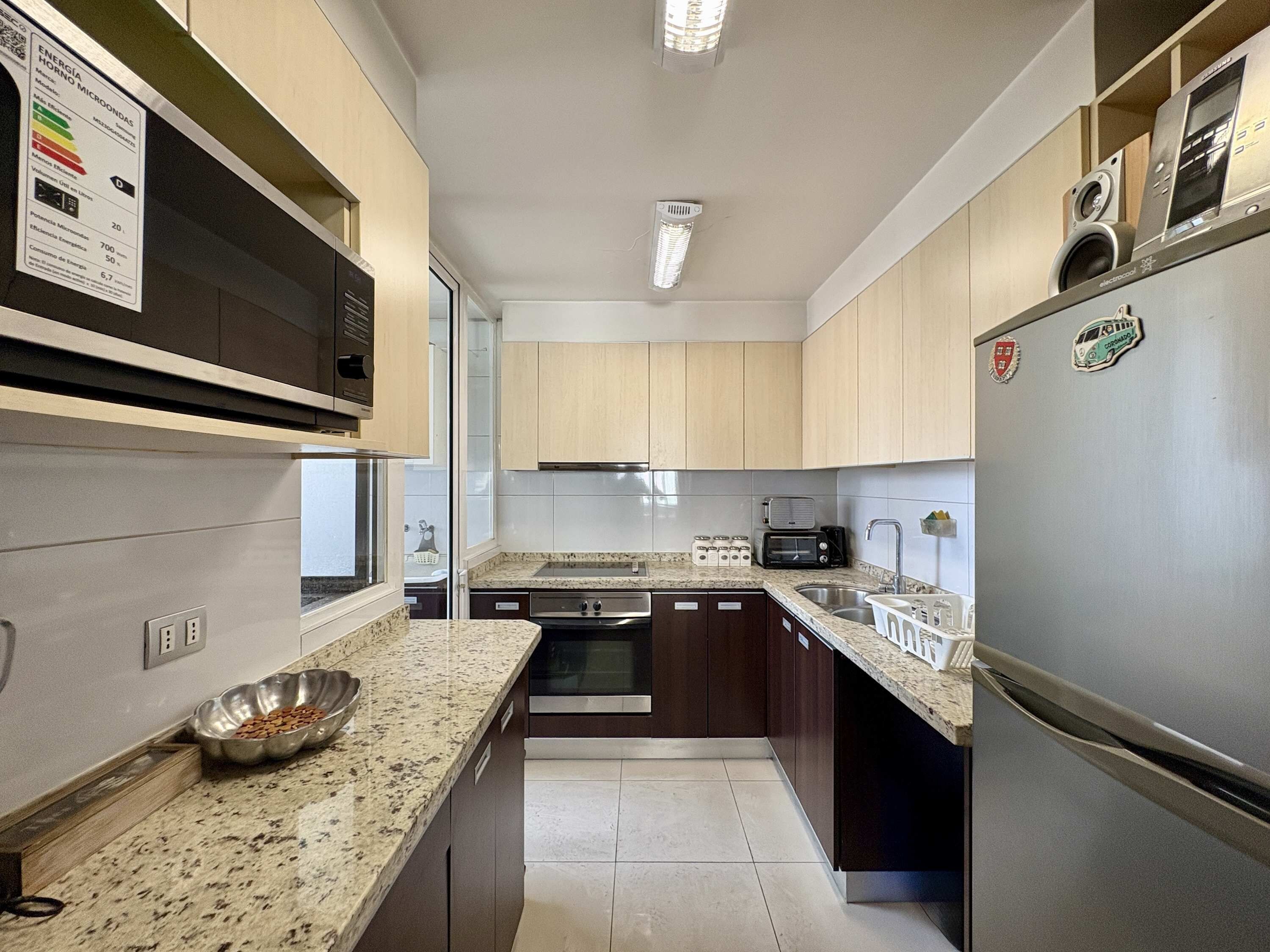 A modern kitchen with granite countertops, stainless steel appliances, and wooden cabinets.