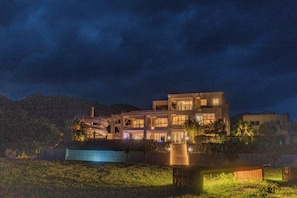 A modern multi-story house with a swimming pool, surrounded by a landscaped garden. - SEARTH KABIRA (Ishigaki)