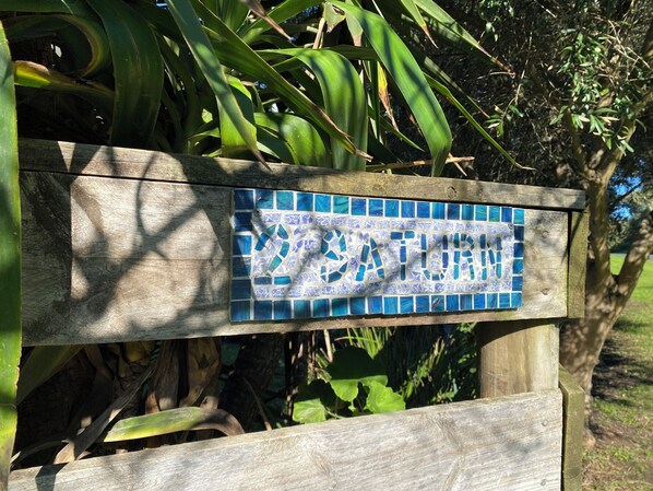 Une enseigne en bois ornée d’une mosaïque de carreaux représentant le mot « NATURE ».