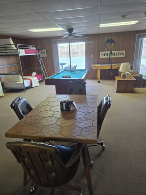 A room with bunk beds, a pool table, a billiards table, and a view of a backyard. - Peaceful Lakefront Retreat | 5* View, Dock, Games (Eatonton)