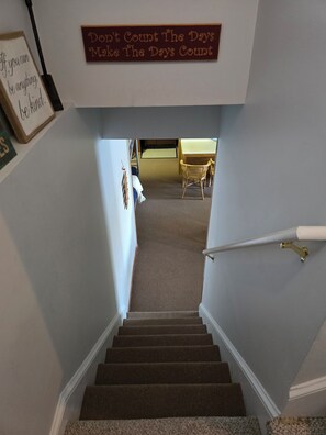 A staircase leading to a room with a sign that reads 'Don't Count The Days Make The Days Count.' - Peaceful Lakefront Retreat | 5* View, Dock, Games (Eatonton)