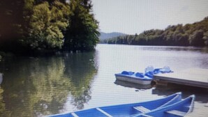 Ein ruhiger See mit einem Steg und zwei blauen Kanus.