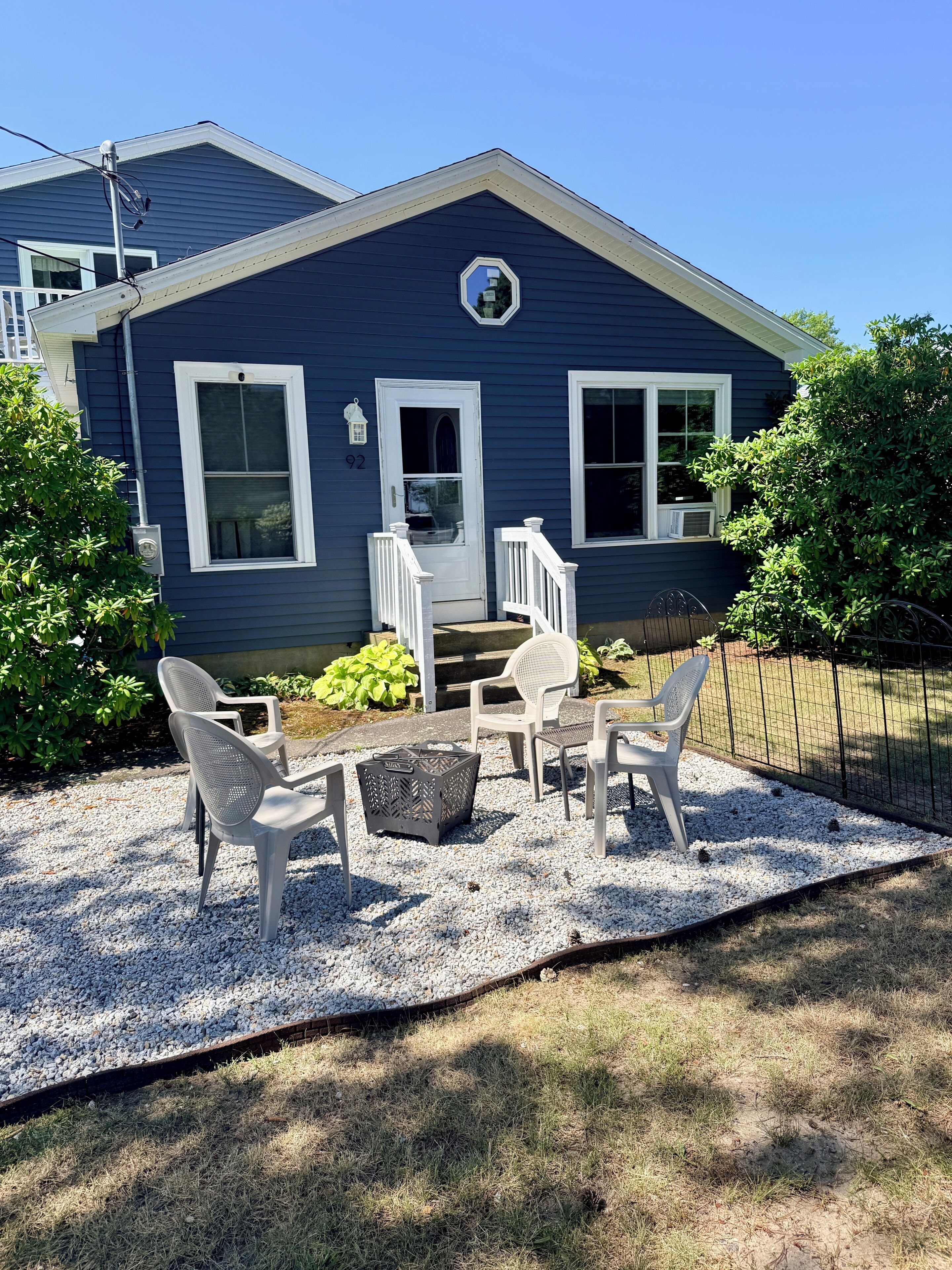 A house with a blue exterior, a white door, and a small porch with white railings.