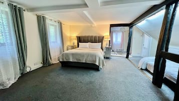 Une chambre d’hôtel avec un grand lit, une table de chevet, une lampe et une vue sur l’extérieur.