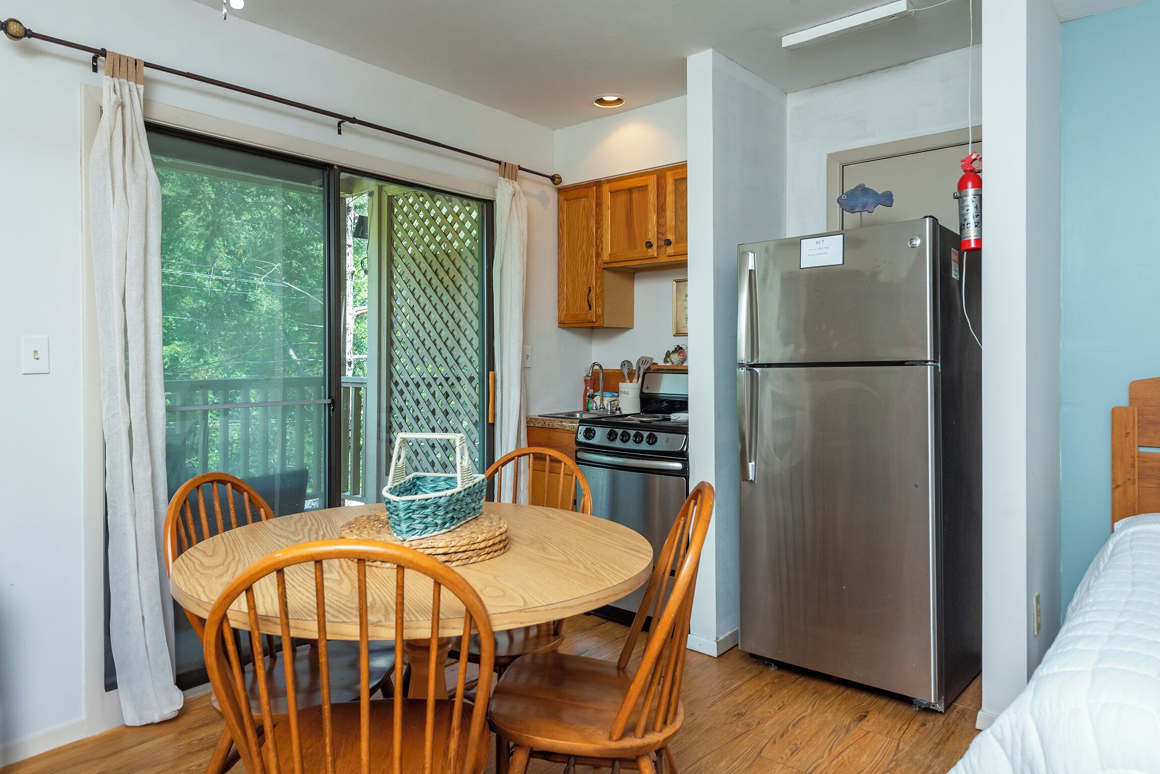 A compact kitchen with a refrigerator, stove, and wooden cabinets.