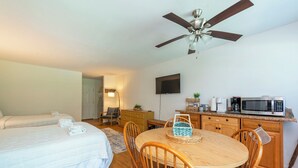 A hotel room with two beds, a dining table, chairs, a ceiling fan, a television, and a kitchenette. - Apple Valley 7 at Rumbling Bald (Lake Lure)