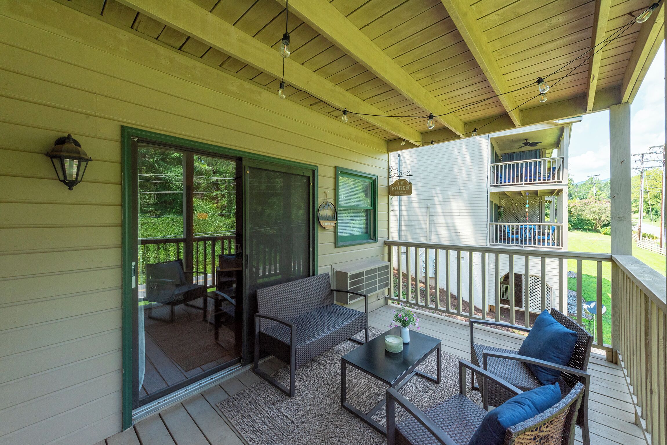 A covered porch with outdoor furniture, a ceiling fan, and a view of the backyard.