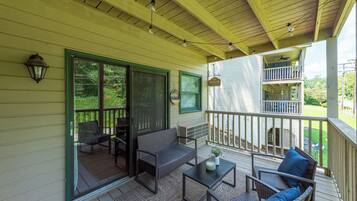A covered porch with outdoor furniture, a ceiling fan, and a view of the backyard.