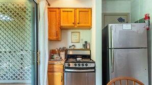 A kitchen with wooden cabinets, a stainless steel stove, and a refrigerator. - Apple Valley 7 at Rumbling Bald (Lake Lure)