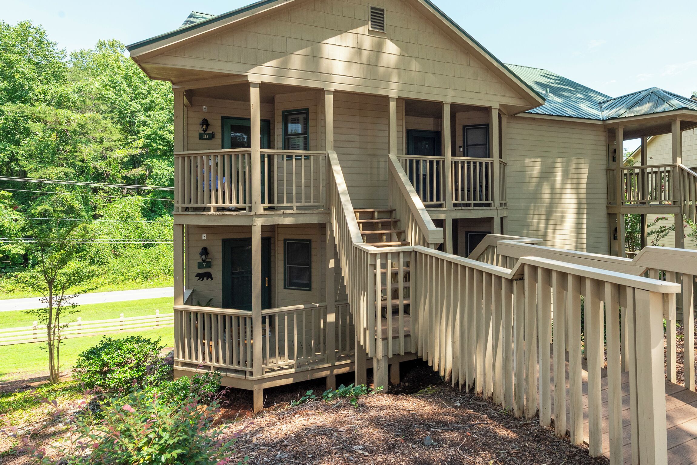 A multi-story house with a balcony on the ground floor and a staircase leading to the upper levels.