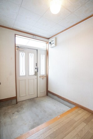 A room with a double door, a light fixture on the ceiling, and a wooden floor. - Niseko Homey Home (Kutchan-cho)