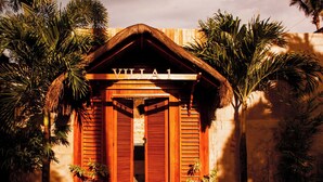 A villa entrance with a wooden facade, a thatched roof, and a sign reading 'VILLA 1'. - California Beach Pansol (Calamba)