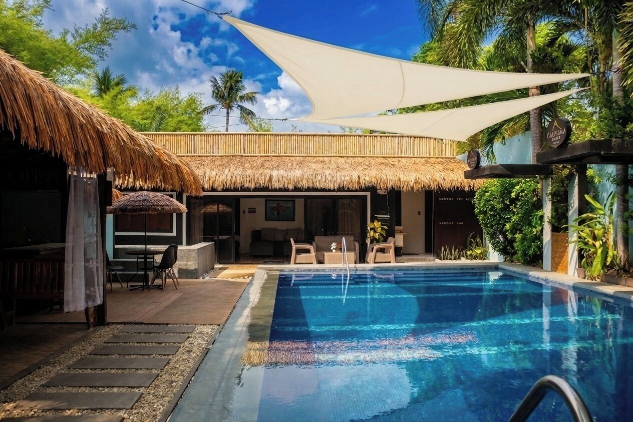 Una piscina con techo de paja, zona de bar y vistas al follaje circundante.