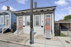 A two-story house with a front porch, a red door, and a mailbox. - Uptown Oasis - 1 Mile from Caesar Superdome (New Orleans)