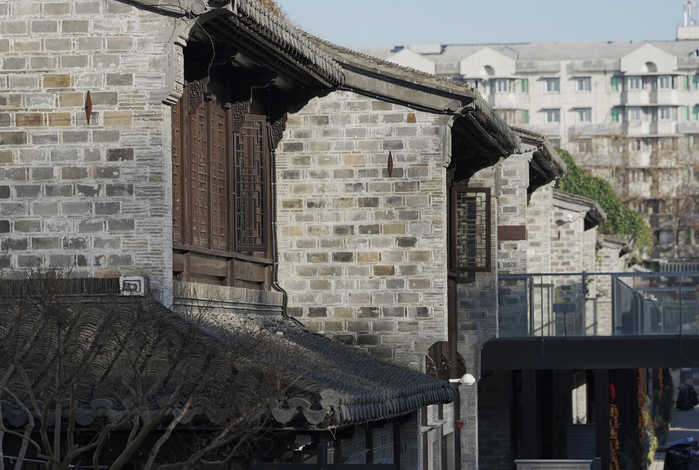 A traditional building with a brick facade, wooden window frames, and a tiled roof.