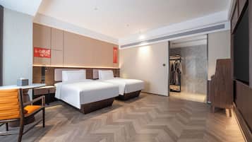 Una habitación de hotel moderna con dos camas, un escritorio y una zona de ducha.