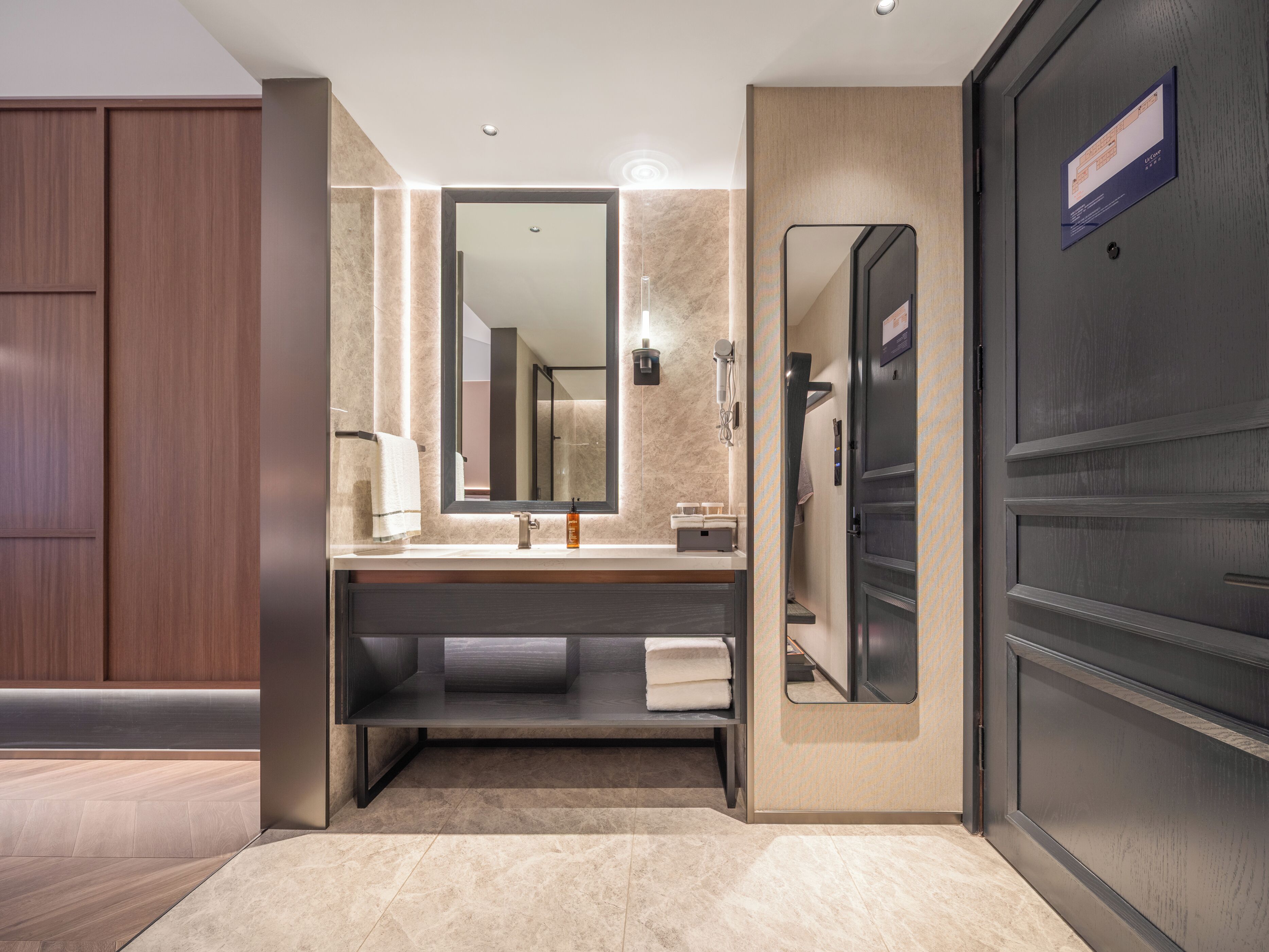 A modern bathroom with a large mirror, a sink, and a shower area.
