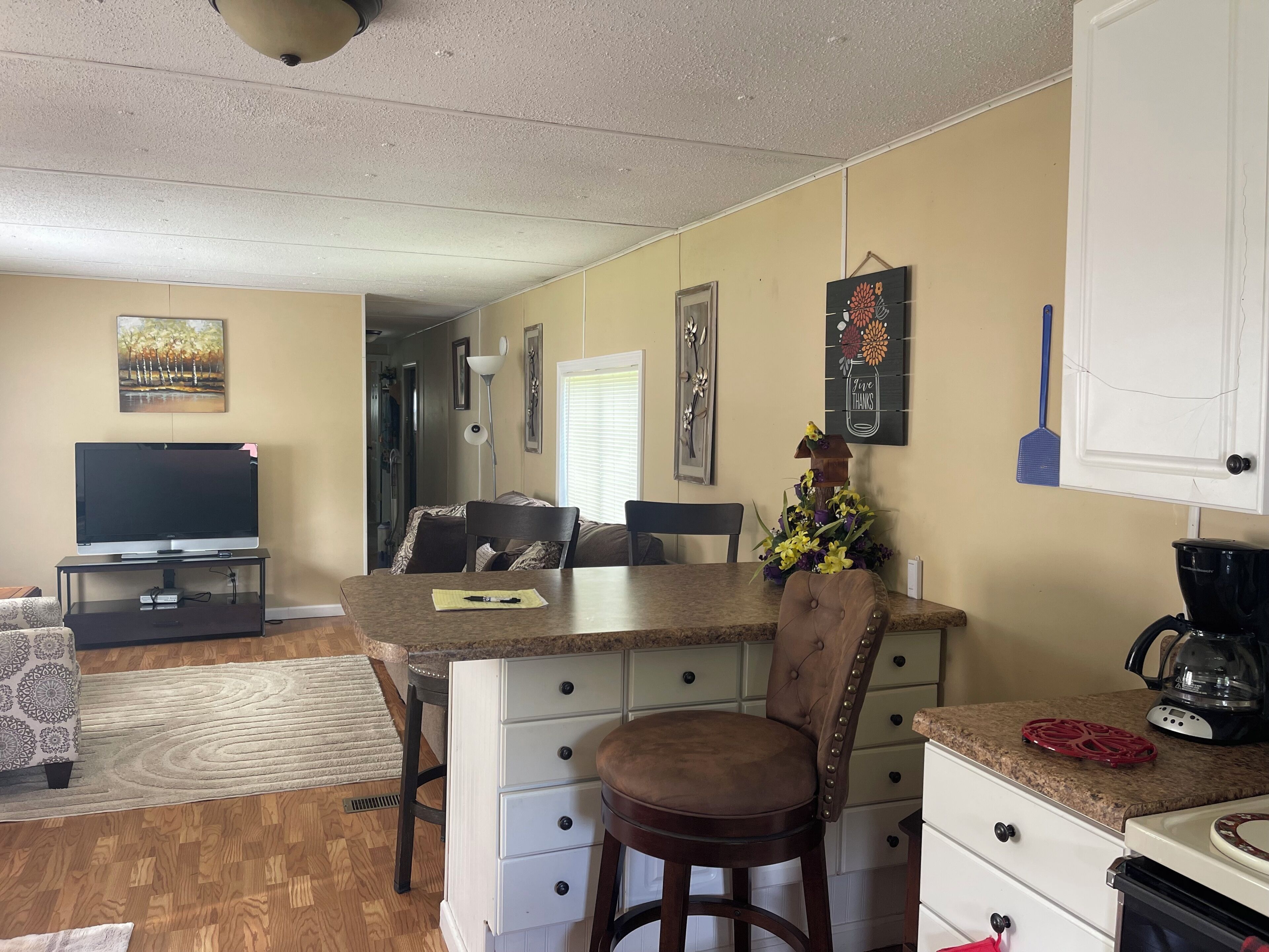 Un espacio habitable compacto con comedor, kitchenette y televisor.