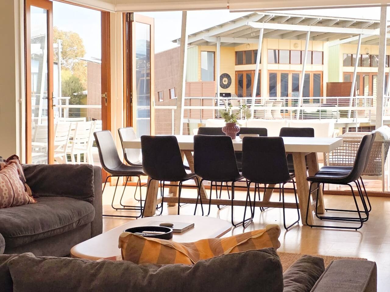 Un salon moderne comprenant un canapé, une table basse et un coin repas avec des chaises et une table.