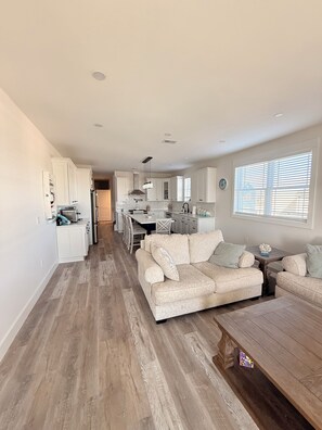 A spacious living area with a sofa, a wooden coffee table, and a dining table with chairs. - 3000 sq. ft, 4-BR, 4 Bath, 3 Blocks to the ocean beach house in Seaside Heights. (Seaside Heights)