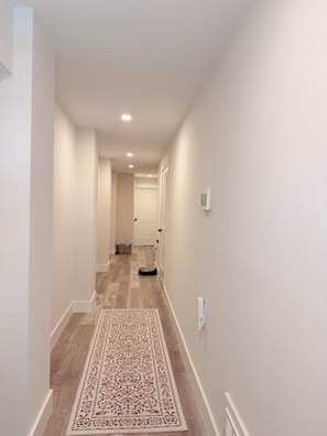 A hallway with a patterned rug, a ceiling light, and a door at the end. - 3000 sq. ft, 4-BR, 4 Bath, 3 Blocks to the ocean beach house in Seaside Heights. (Seaside Heights)