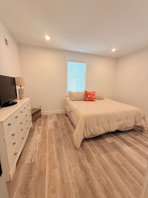 A bedroom with a bed, a dresser, a television, and a window with blinds. - 3000 sq. ft, 4-BR, 4 Bath, 3 Blocks to the ocean beach house in Seaside Heights. (Seaside Heights)