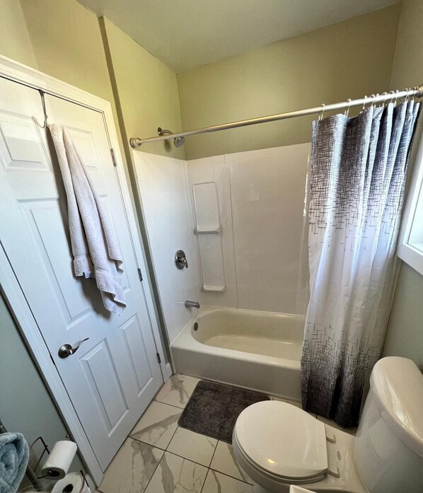 Ein Badezimmer mit Badewanne, Toilette und Duschvorhang.