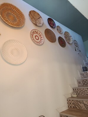 Eine Wand mit verschiedenen gewebten Körben und dekorativen Tellern.