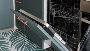 Una cucina con lavastoviglie, forno a microonde e piano di lavoro in marmo.