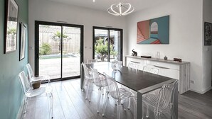 A modern kitchen with a dining area, large windows, and a view of the backyard. - Gorgeous home in Leon (Leon)