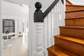 A staircase with white balusters and a black handrail leading to a landing. - Stylish 3BR Terrace Near Sydney CBD & USYD (Darlington)