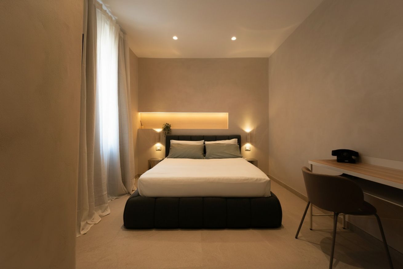 Una camera da letto moderna con un letto, comodini, una scrivania e una sedia.