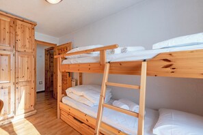 A bunk bed room with wooden furniture and a wardrobe. - Family Apartment Steps From Ski Lifts, Courmayeur, Italy (Courmayeur)