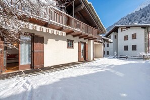A snow-covered building with wooden balconies and a clear sky. - Family Apartment Steps From Ski Lifts, Courmayeur, Italy (Courmayeur)